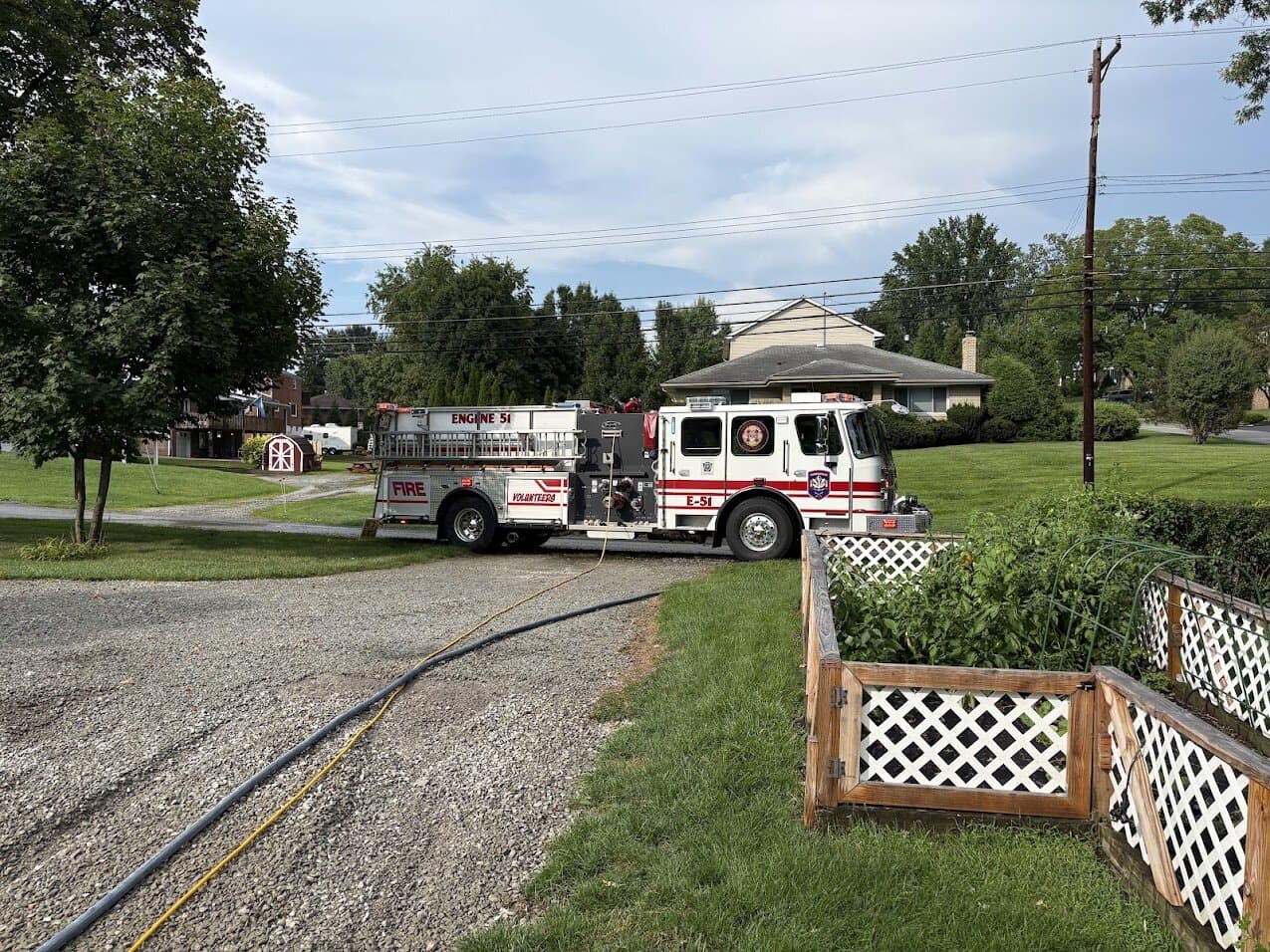 Engine 51 with a supply line laid across a driveway